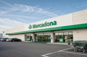Façade extérieure d'un supermarché Mercadona en France avec enseigne verte et parking