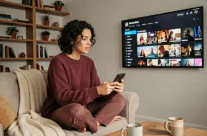 Femme regardant des séries recommandées sur une plateforme de streaming depuis son canapé